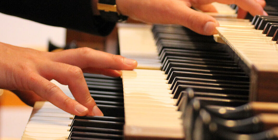 Das Bild zeigt Hände auf einer Orgeltastatur